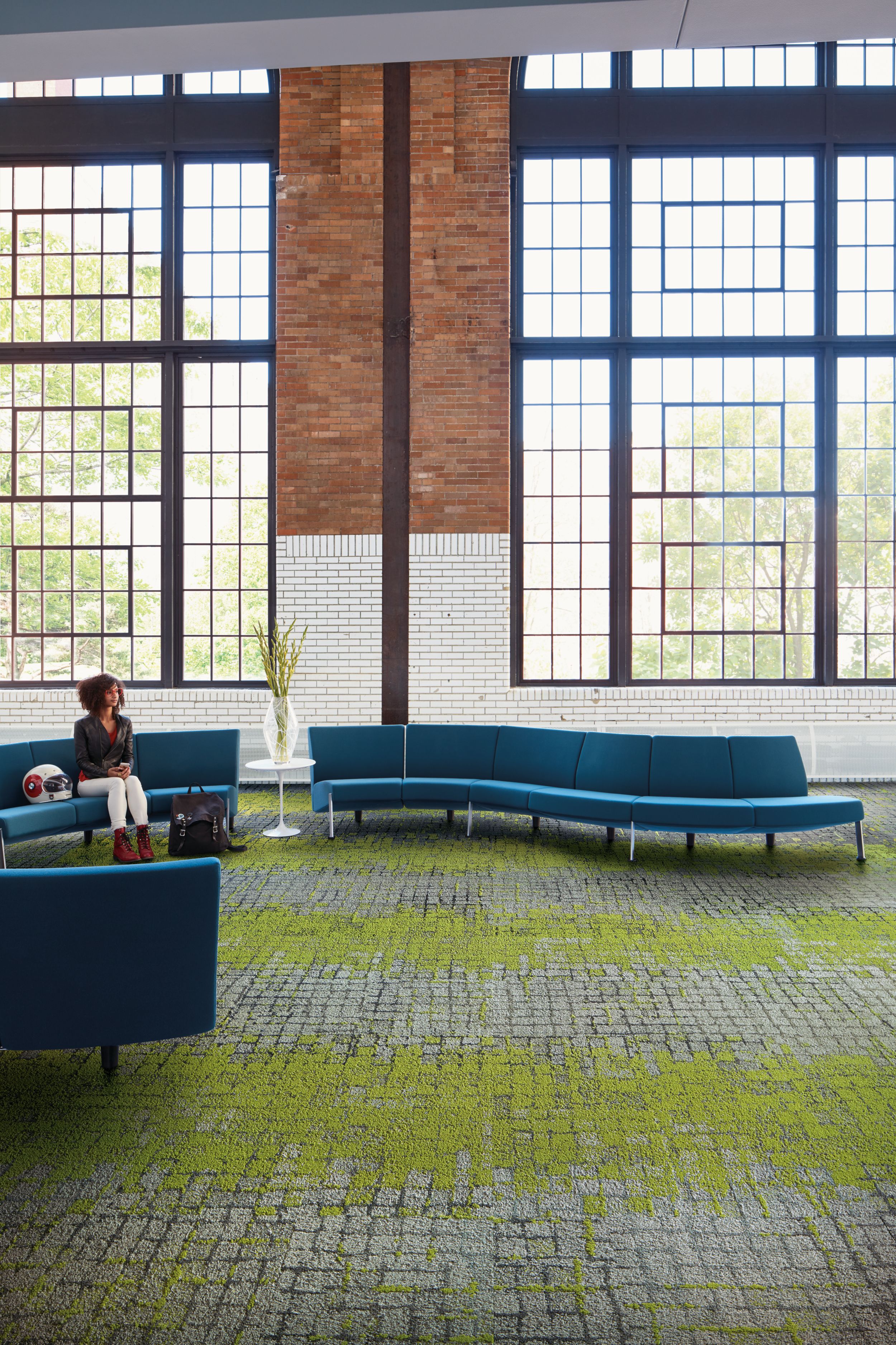 Interface Moss and Moss in Stone carpet tile in seating area with blue couches and women seated número de imagen 4